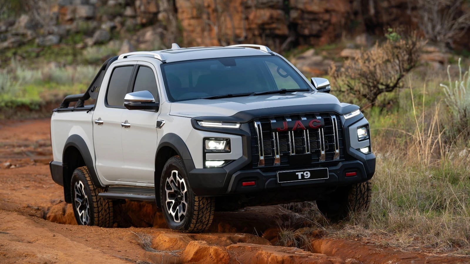 A white JAC T9 Super Lux 4x4 double cab climbing a rocky koppie track