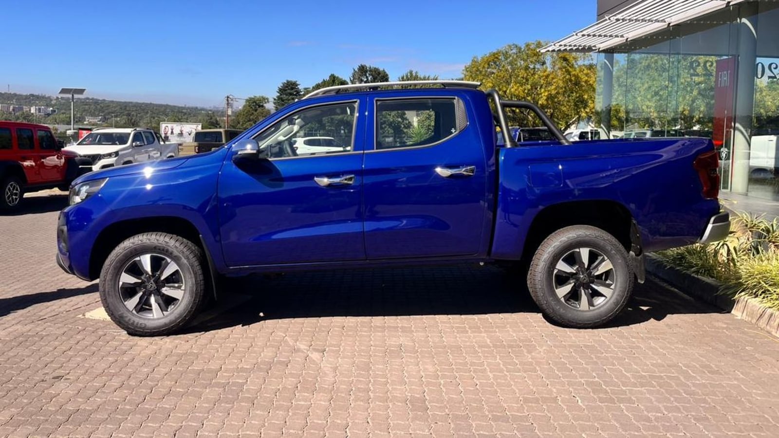 A white 2026 Peugeot Landtrek 1.9D Allure double cab automatic in side profile on brick paving in Sandton