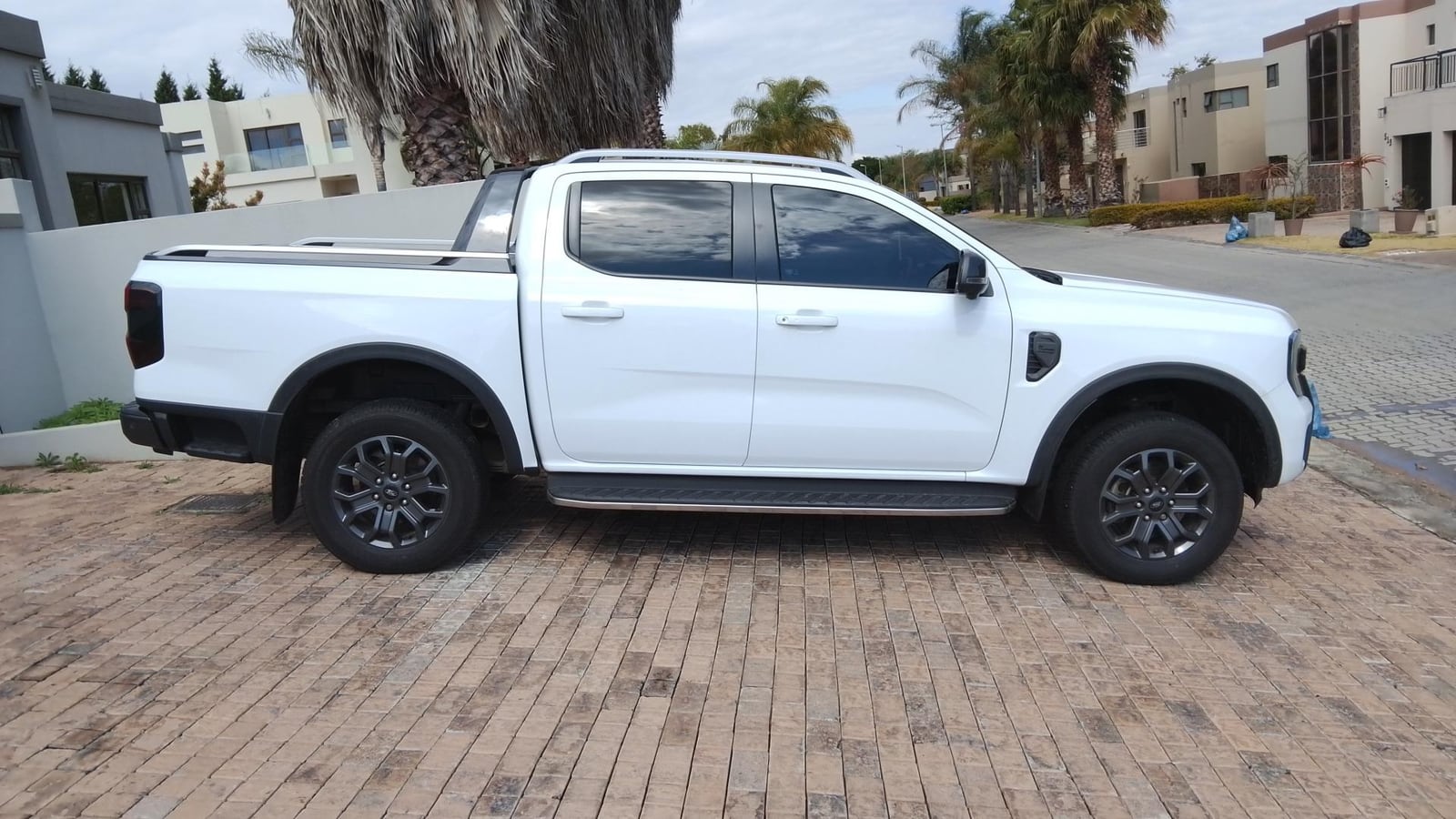 A white 2023 Ford Ranger Wildtrak double cab parked side-on in a paved driveway in a Gauteng estate