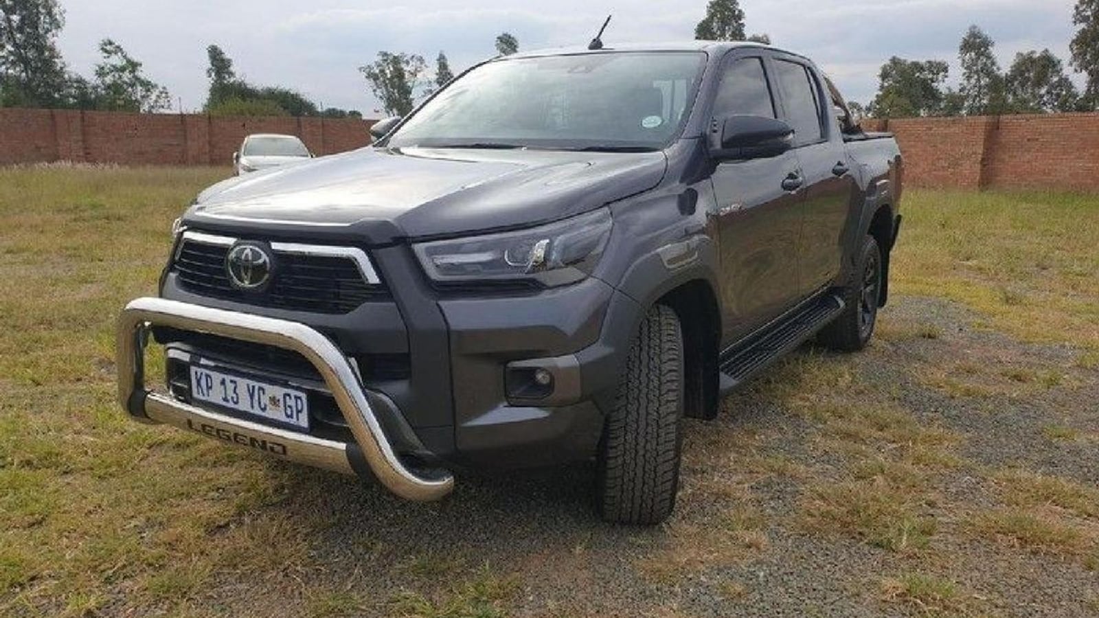 A graphite 2022 Toyota Hilux 2.8 GD-6 Legend automatic double cab with a nudge bar, parked on dry Highveld grass in Gauteng