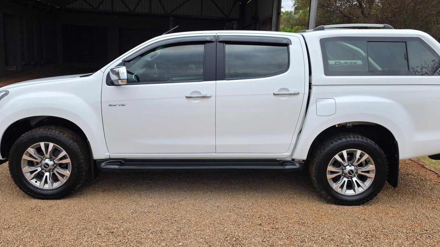 A white 2020 Isuzu D-Max 300 3.0TD LX automatic double cab with a colour-coded canopy, side on, on a gravel driveway in front of a steel shed in Gauteng
